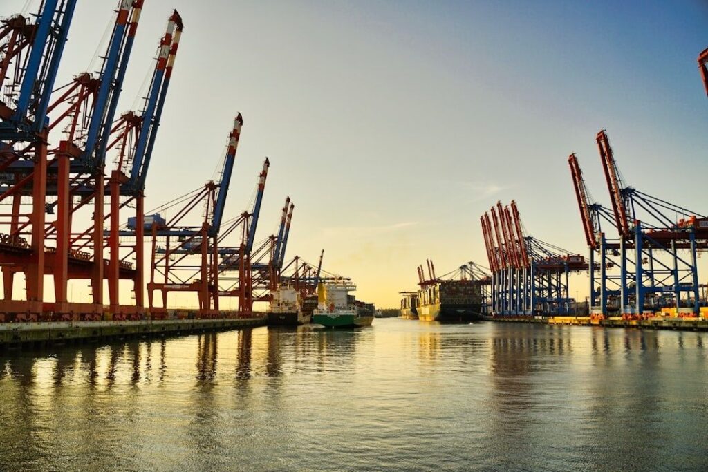 Containerhavn med kraner og fragtskibe ved kajen