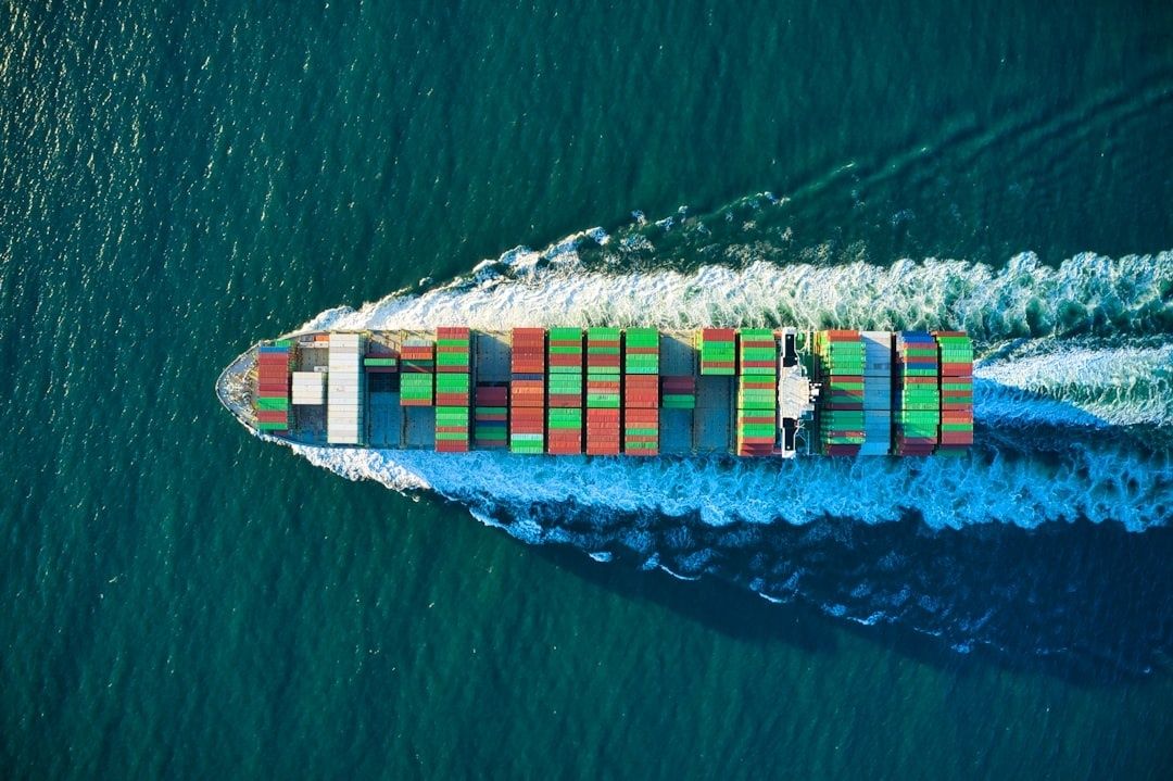 Containerfragtskib sejler gennem havet med bølger omkring skroget